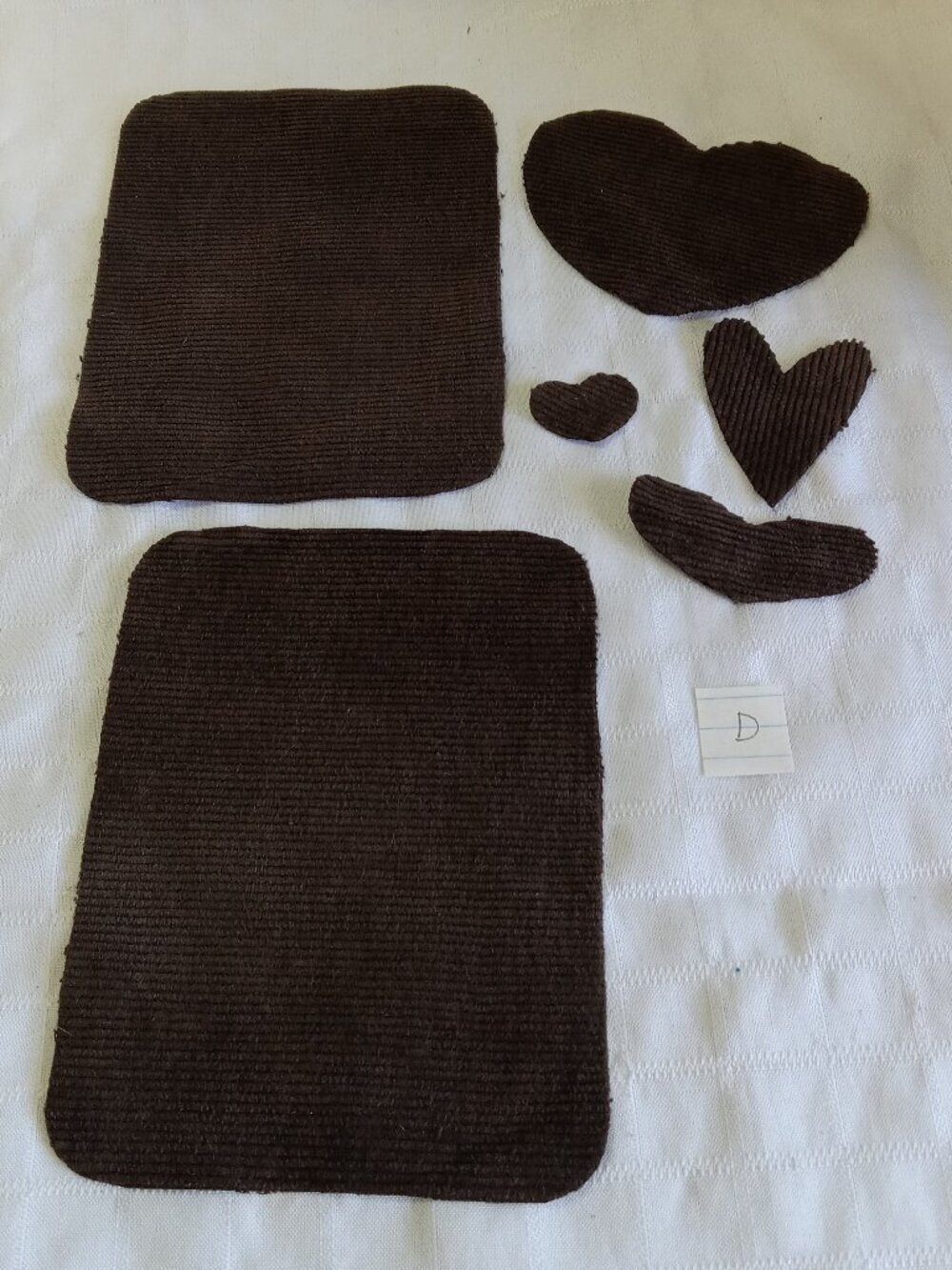 Two handmade elbow patches for sewing made of brown corduroy with hearts